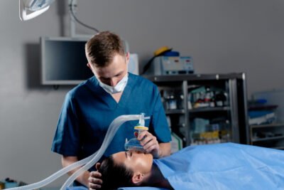 Anesthesiologist making ingalation anesthesia for patient. Doctor puts a mask on the patient before starting operation