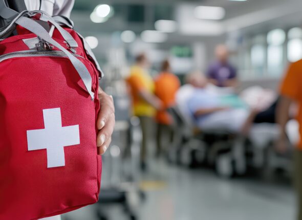 Doctor carrying a first aid kit in a busy hospital emergency area for patient care